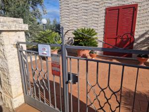 a fence with a red door and some plants at Villa Rosanna's Haven Terrazza e Parcheggio- by Gessica Home in Antonelli