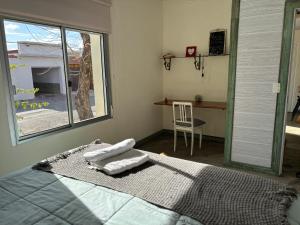 ein Schlafzimmer mit Bett, Fenster und Schreibtisch in der Unterkunft Calm in Carmelo
