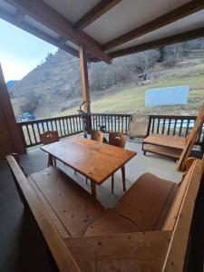 a wooden table and chairs on a porch with a view at Apartment 10 minutes from Verbier in Bagnes