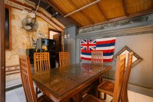 a dining room with a table and a flag on the wall at Hawaiian Beach House in Legian