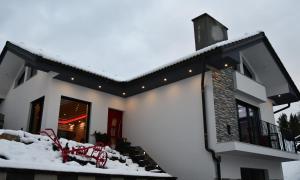 una casa blanca con nieve en el suelo en Holiday House Vikend, en Polzela