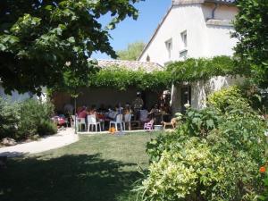 un grupo de personas sentadas en el patio de una casa en Gîte Le Duzon, en Plats
