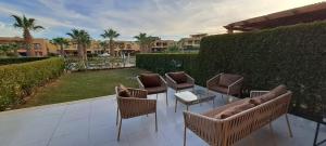 艾因苏赫纳Mountain View Sokhna 1, Villa 4 Bedrooms, Direct to Pool, 300 M to Beach & Dayra Camp, Families ONLY的庭院里摆放着几把椅子和桌子 更多29张照片