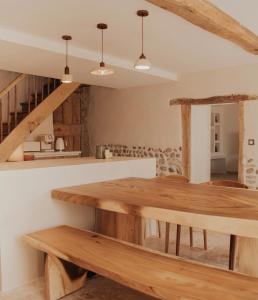 une cuisine avec une table en bois et un escalier dans l'établissement Charmante maison en pierres, séjour à la ferme, à Saint-Georges-dʼEspéranche 34 autres photos