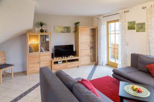 a living room with a couch and a tv at Ferienwohnung Rosalie in Westerndorf