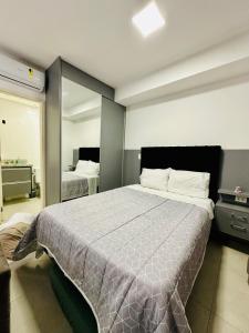 a bedroom with a large bed and a mirror at Studio Duo Jk Platinum 13 in Sao Jose do Rio Preto