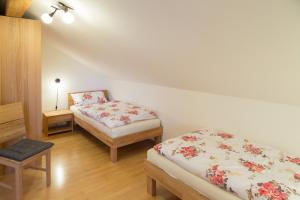 1 Schlafzimmer mit 2 Betten, einem Tisch und einem Stuhl in der Unterkunft Ferienwohnung Rosalie in Westerndorf