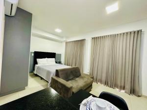 a hotel room with a bed and a chair at Studio Duo Jk Platinum 13 in Sao Jose do Rio Preto +29 photos