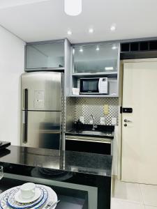 a kitchen with a stainless steel refrigerator and a sink at Studio Duo Jk Platinum 13 in Sao Jose do Rio Preto