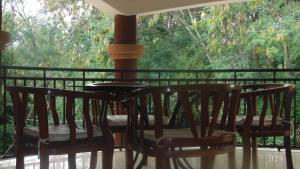 a table and chairs on a porch with a view of trees at Njiro Ebenezer Retreat Lodge in Arusha