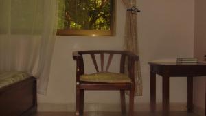 a chair in a room with a table and a window at Njiro Ebenezer Retreat Lodge in Arusha