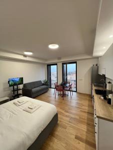 a bedroom with a bed and a kitchen and a living room at LikeHome PortaReno Monolocale Exclusive - 4 pxs in Ferrara