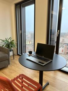 a laptop computer sitting on a table in a living room at LikeHome PortaReno Monolocale Exclusive - 4 pxs in Ferrara