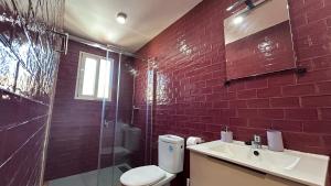 Un baño con inodoro, ducha y lavabo. en Ático en arenas de malaga, en Arenas 31 fotos más