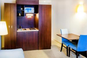 a small room with a table and a kitchen at Appart'hôtel Saint Jean in Lourdes