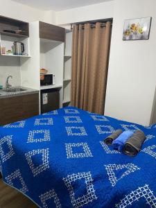 a blue bed with a blue comforter in a room at MonoAmbiente 31 in Cochabamba