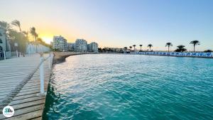 une plage avec une jetée, des bâtiments et l'océan dans l'établissement Scandic Resort Hurghada, à Hurghada