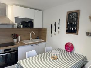 a kitchen with a table with chairs and a sink at Chez Coco in Marvejols