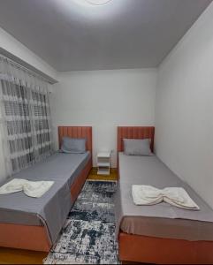 two twin beds in a room with a window at C&E Apartment in Struga