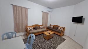 a living room with two couches and a table at Apartement in Houmt Souk