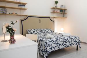 een slaapkamer met een bed en een vaas met bloemen op een tafel bij Fra i Cavalieri e i Miracoli a 2 passi da tutto in Pisa