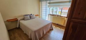 a bedroom with a bed and a window at A pie de playa in Aldán
