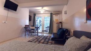 a living room with a couch and a table and chairs at Studio Murdeira Side Beach, Eco Protected Bay, Pool 161B in Beirona