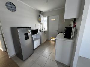 Una pequeña cocina con nevera y fregadero. en Acogedora Casa Nueva, en Puerto Montt 11 fotos más