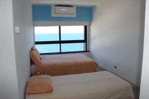 a small room with two beds and a window at Ondina Apart Hotel Cobetura in Salvador +99 photos