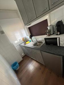 a small kitchen with a sink and a microwave at Apartamento Salou 2 playas, 2 km PortAventuraWorld in Salou