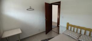 a bedroom with a bed and a table and a door at Casa Grande no Olaria in Lavras
