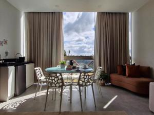 a living room with a table and chairs and a couch at Melhor Apartamento de Bananeiras 3 quartos in Bananeiras