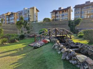 a wooden bridge over a stone wall with flowers at Melhor Apartamento de Bananeiras 3 quartos in Bananeiras