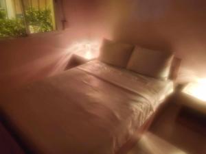 à 10 minutes du grand mall d'Afrique, WiFi Netflix 1ère étage في Oulad Hamida: غرفة نوم بسرير ابيض واضاءين