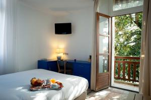Un dormitorio con una cama con una bandeja de fruta. en Hôtel Le Dauphin en Arcachón
