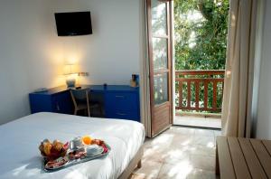 una habitación de hotel con una bandeja de comida en una cama en Hôtel Le Dauphin, en Arcachon