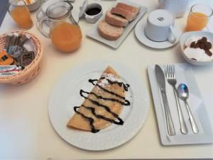 stół z białym talerzem i kawałkiem ciasta w obiekcie Blue Harmony Apartments w mieście Plaka +37 zdjęć