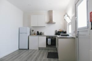 a kitchen with white appliances and a white refrigerator at Central Charm Azores in Ribeira Grande +9 photos