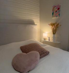 House with a beautiful seaview في ترومسو: وسادة على شكل قلب على سرير ابيض +23 صورة