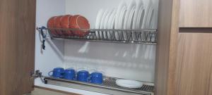 a shelf in a kitchen with plates and blue cups at Apartamento C&B in Bello +8 photos