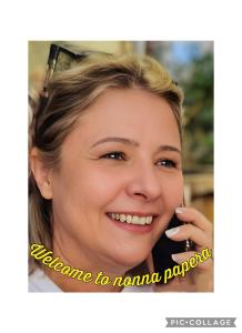 a woman smiling while talking on a cell phone at Casa Vacanze Nonna Papera near Cinque Terre in Bolano