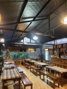 a restaurant with wooden tables and benches in a room at Bó Bun Homestay Mộc Châu in Mộc Châu