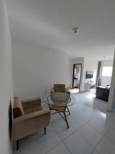 a living room with two chairs and a glass table at Nosso lar in Campina Grande +1 photo