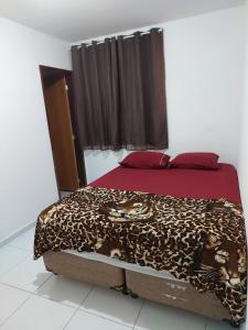 a bed in a room with a leopard blanket on it at Nosso lar in Campina Grande