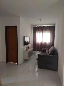 a living room with a couch and a window at Nosso lar in Campina Grande