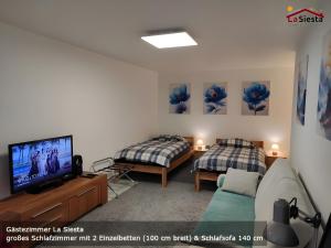 a living room with two beds and a television at Gästezimmer La Siesta in Ötisheim