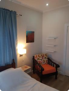 una camera con letto, sedia e lampada di Serenity at Buccoo, Ensuite Room a Buccoo