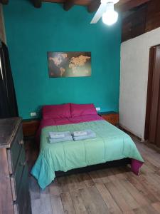 a bedroom with a bed with two towels on it at MONOAMBIENTES LOS SAUCES in Mina Clavero