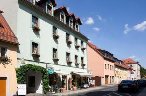 um edifício numa rua com carros estacionados na rua em Altstadthotel "Garni" Grimma em Grimma
