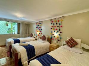 a bedroom with three beds and a window at Tika house in Cusco